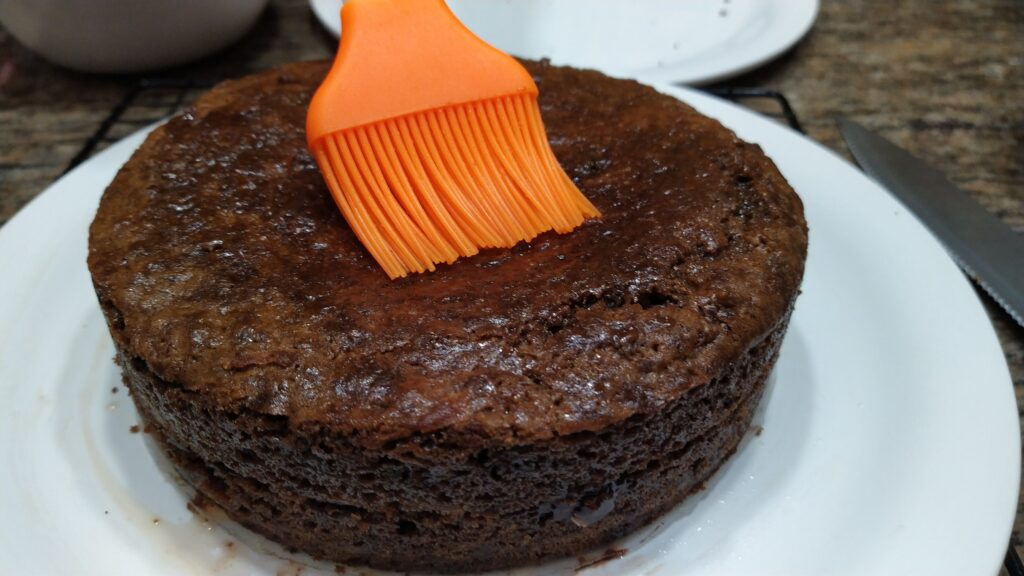 Brush the top with Rum flavoured simple syrup before pouring on the ganache